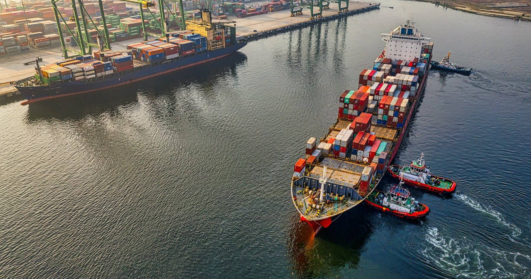 Navire porte-conteneurs remorqué dans un chenal de navigation